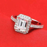 Silver engagement ring with a round blue sapphire gemstone and prong setting on a red background