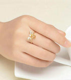 Woman's hand wearing a natural oval citrine bee wedding ring in sterling silver with prong setting