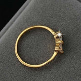 Princess zircon gold ring for women with bezel set stones and bowknot design on gray background