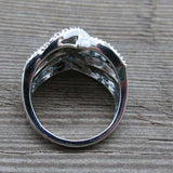 Silver white sapphire gemstone women's cocktail ring with prong setting on wooden surface