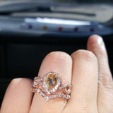 Rose gold morganite engagement ring set with pear-shaped center stone and diamond accents on finger