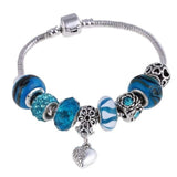 Silver charm bracelet with blue beads and heart pendant