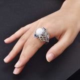 Vintage opal cat eye ring with hollow silver feather design and large stone on woman's hand