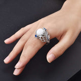 Vintage opal cat eye ring with hollow silver feather design and large oval stone on woman's hand