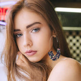 Close-up of a woman wearing luxury silver geometric drop earrings with acrylic accents for women wedding jewelry