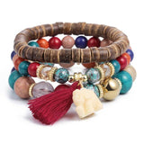 Vintage wristband beaded bracelet for women with multicolor beads, wooden accents, gold charms, and a red tassel in bohemian style