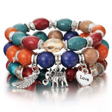 Vintage wristband beaded bracelet for women with colorful beads and silver charms including a heart, elephant, and wing charm