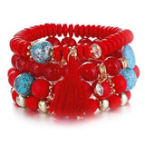 Vintage wristband beaded bracelet for women with red and turquoise beads, gold accents, and red tassel charm in bohemian style