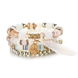 Vintage wristband beaded bracelet for women with charm, gold accents, and white feather detail
