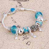 Silver charm bracelet with blue zircon beads and intricate plant-shaped charms for women