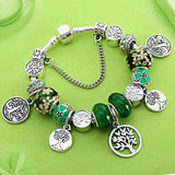 Tree of Life charm bracelet for women with Tibetan silver beads and green enamel floral accents on green background